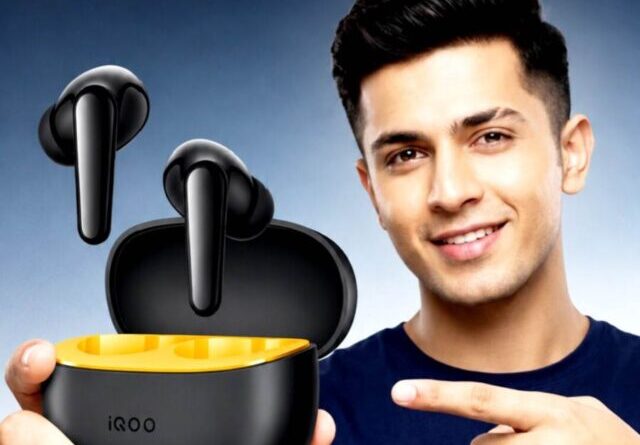 Man holding open case of iQOO TWS earbuds with black and yellow design