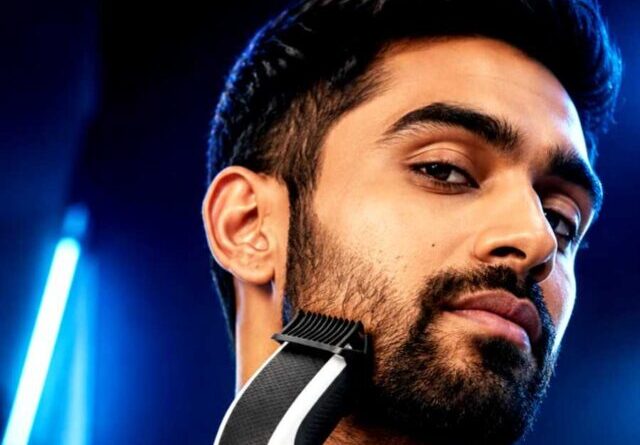 young man styling beard with philips cordless beard trimmer